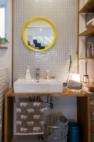 黄色の鏡が映えるタイル張りの洗面台を造作。